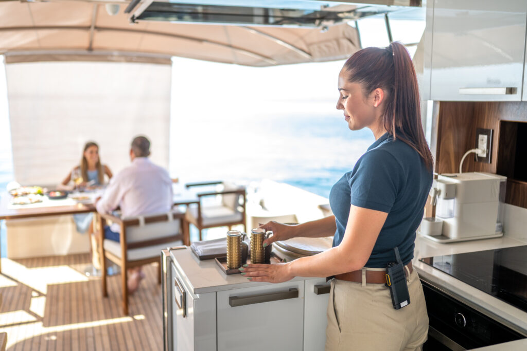 Smiling stewardess working on a luxury yacht.