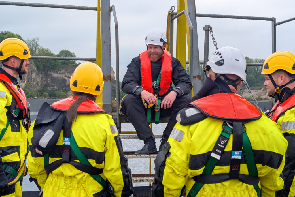 GWO Basic Safety Training GWO Basic Safety Training students listing to an instructor while wearing their sea survival equipment at South West Maritime Academy awaiting to carry out a vessel transfer exercise.
